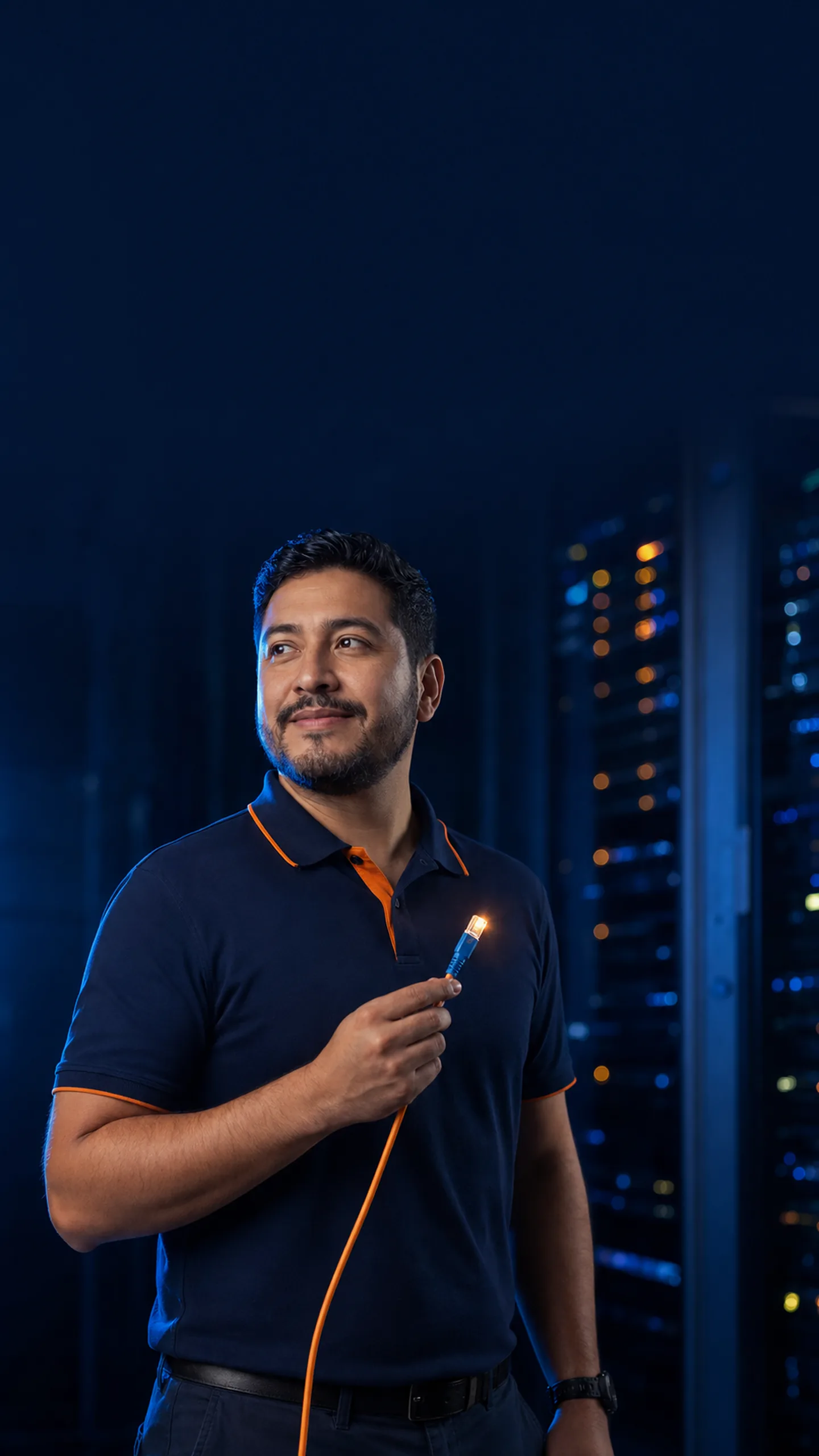 Ingeniero de red de ColinaNet sosteniendo un conector de fibra óptica encendido frente a racks de un data center